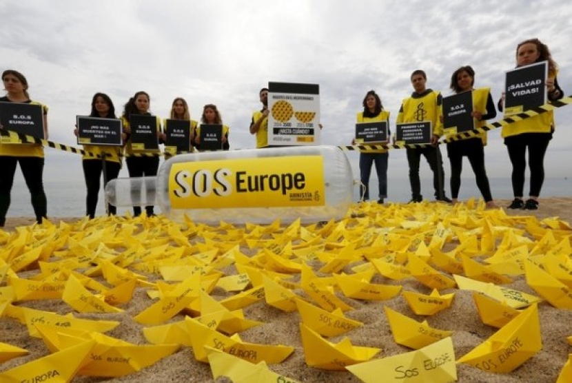 Sukarelawan dari Amnesty International melakukan aksi meletakkan kapal kertas di sebuah pantai di Barcelona, Spanyol. Kapal yang diberi tulisan SOS Europe itu merupakan keprihatinan dari banyak imigran yang meninggal di kapal saat hendak masuk ke Eropa. Sumber:Reuters, file (Republika.co.id)