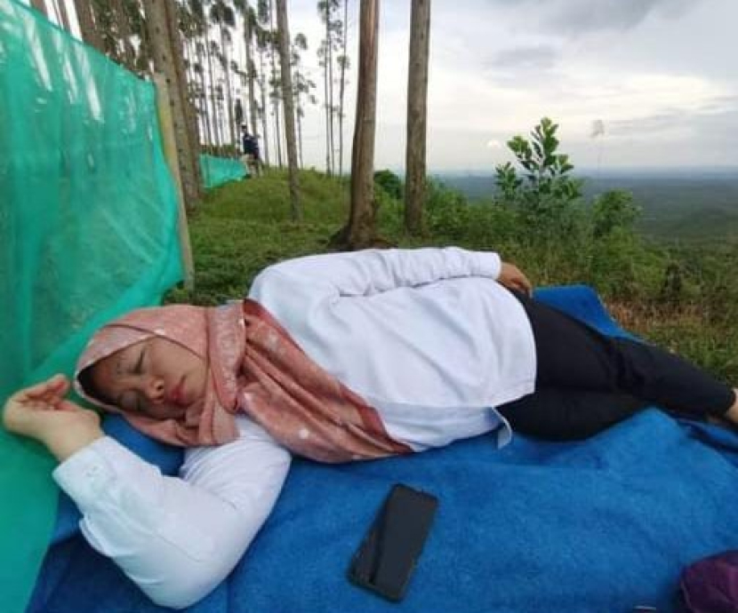 Medsos Facebook milik Ketua Dewan Adat Dayak Kabupaten Penajam Paser Utara, Helena Lin Legi, terdapat foto yang menarik perhatian, yakni Susianah Affandy sedang tidur dengan alas terpal sekadarnya di atas gunung IKN. (Foto: Facebook Helena)