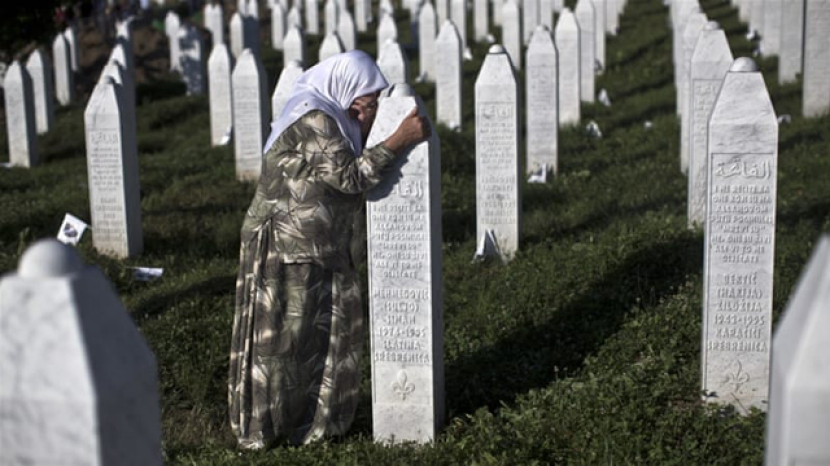 Muslimah Bosnia menangis di nisan keluarganya yang menjadi korban pembantaian tentara Serbia di Sebrenica.