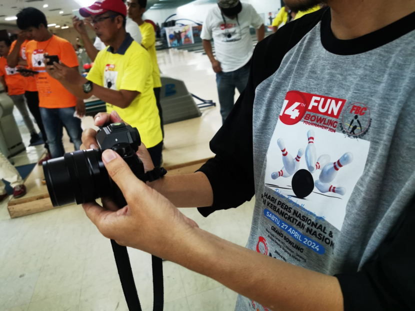 Jurnalis perserta 14th Fun Bowling Tournament 2024 mengabadikan momen turnamen di sela perlombaan turnamen bowling di Grand Bowling Serpong, Sabtu (26/4/2024) 