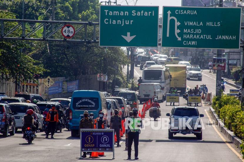 Kawasan Puncak Bogor. Seorang petugas polisi berjaga di pertigaan Gadog untuk memberi tahu tentang peraturan ganjil genap. Foto: Republika.