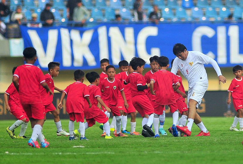 Mantan bek Persib Bandung Robby Darwis dikerubuti puluhan siswa SSB pada laga funsoccer jelang pembukaan Turnamen Piala Presiden 2024 di Stadion Si Jalak Harupat, Kabupaten Bandung, Jumat (19/7/2024). Bersama lima mantan pemain tim Persib Atep, Zaenal Arief, Yaris Riyadi, Eka Ramdani, dan Markus Horison melawan 63 siswa SSB se-Bandung Raya. (FOTO: YOGI ARDHI/REPUBLIKA NETWORK) Nikon D3, Nikkor 300/2.8 ED MF.