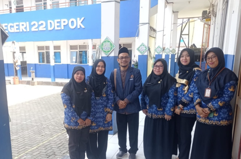 Syahruddin, ketiga kiri, berfoto bersama dengan kepala sekolah SMPN 22 Depok, Eriyasti, didampingi sejumlah dewan guru.