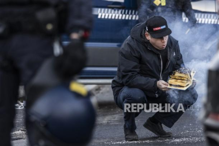 Rasmus Paludan, pemimpin partai anti-Islam sayap kanan Denmark Stram Kurs (Garis Keras), membakar mushaf Alquran di depan kedutaan Turki di Kopenhagen, Denmark, Jumat (27/1/2023). Aksi itu ditanggapi dengan kemarahan dan protes dari warga Muslim Dunia sejak Paludan membakar kitab suci umat Islam di Stockholm seminggu sebelumnya. (EPA-EFE/Olafur Steinar Gestsson)