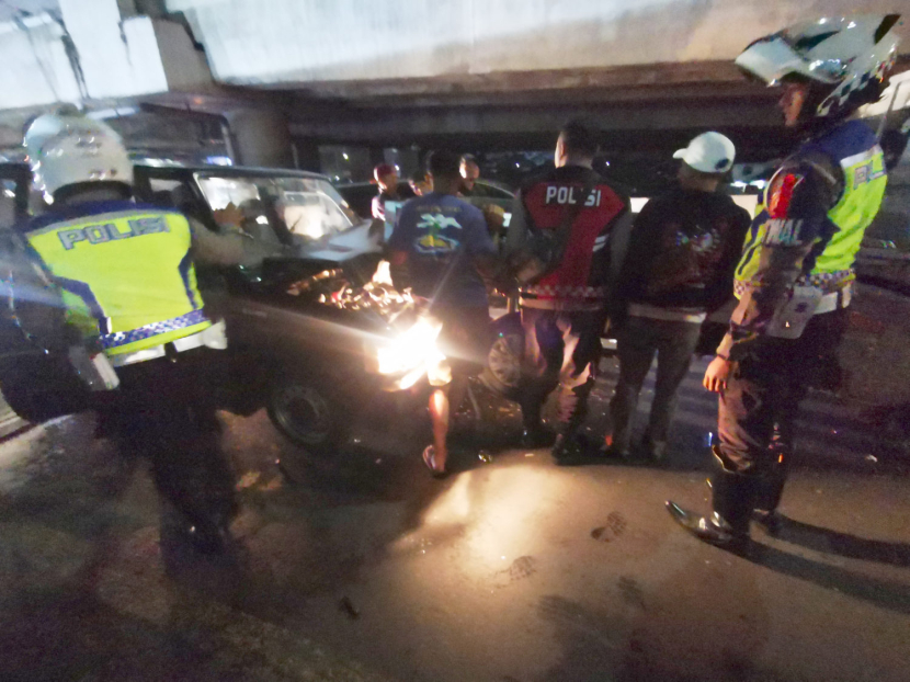 Warga dan petugas polisi mengevakuasi minibus yang terlibat tabrakan beruntun di Ramp jalan tol menuju Gerbang Tol Cileunyi, Jumat (12/4/2024) malam. Foto: Yogi Ardhi/Republika Network