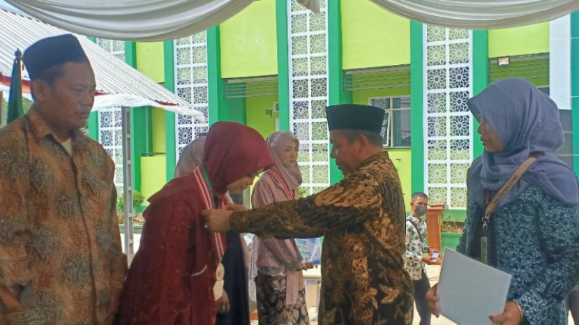 Kakankemenag Kabupaten Tuban Ahmad Munir mengalungkan medali emas kepada juara Master Sains Competition Point 4.0 Nasional, di Tuban, Jawa Timur Sabtu (18/06/22). Foto : pendis.kemenag.go.id