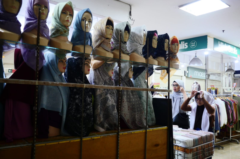 Seorang pengunjung Baltos Bandung mencoba kain kerudung yang akan dibelinya. Penurunan minat belanja di tengah kenaikan jumlah dan frekuensi belanja masyarakat di tengah bulan Ramadhan. (Foto Dokpri)