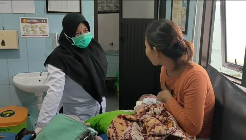 Bidan berbincang dengan Ayu Sari yang sedang memangku bayi yang baru dilahirkannya. (Istimewa)