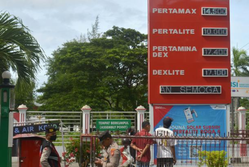 Polisi melakukan pengamanan saat berlangsungnya pemasangan informasi harga terbaru bahan bakar minyak (BBM) di salah satu SPBU. (Antara).