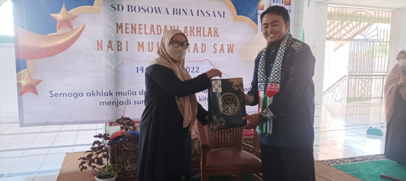 Kepala Sekolah SD Bosowa Bina Insani, Dra Eka Rafikah menyerahkan kenang-kenangan kepada pendongeng Kak Dede Kemdo. (Foto: SBBI)