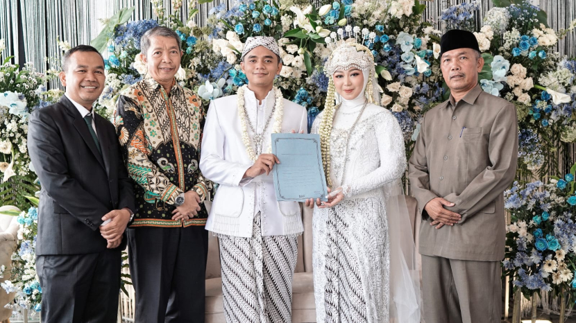 Pasangan pengantin baru menerima KTP dan KK baru setelah ijab kabul. (Dok Diskominfo Kabupaten Kuningan)