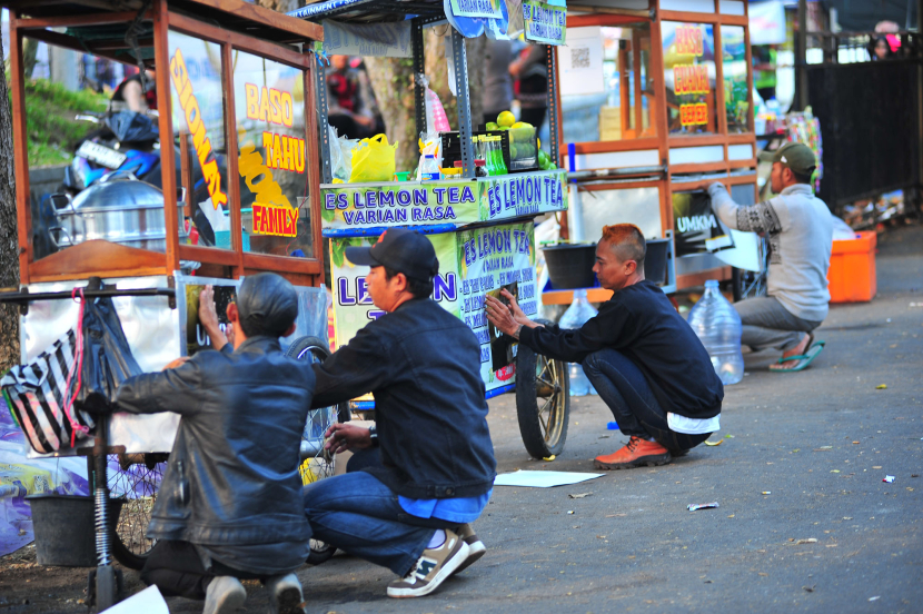 Sejumlah pedagang makanan memasang stiker UMKM Piala Presiden pada gerobak dagangannya di ajang turnamen Piala Presiden 2024 di Stadion Si Jalak Harupat, Soreang Kabupaten Bandung, Kamis (25/7/2024). Foto: Yogi Ardhi/Republika Network