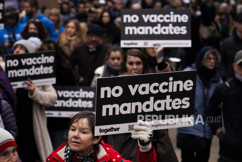 Orang-orang memegang plakat saat mereka menghadiri protes anti vaksin di London, Inggris, Sabtu, 22 Januari 2022. AP/Alberto Pezzali