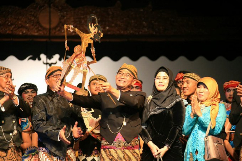 Menko PMK Prof Muhadjir Effendy mainkan wayang. Meski dari keluarga santri, Prof Muhadjir pandai memainkan wayang, karena ia memiliki ayah seorang dalang. Foto: Kemenko PMK.