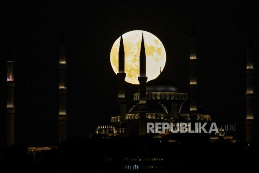 Bulan purnama terbit di belakang Masjid Agung Camlica di Istanbul, Turki, Selasa, (1/8/2023). Foto: EPA-EFE/SEDAT SUNA