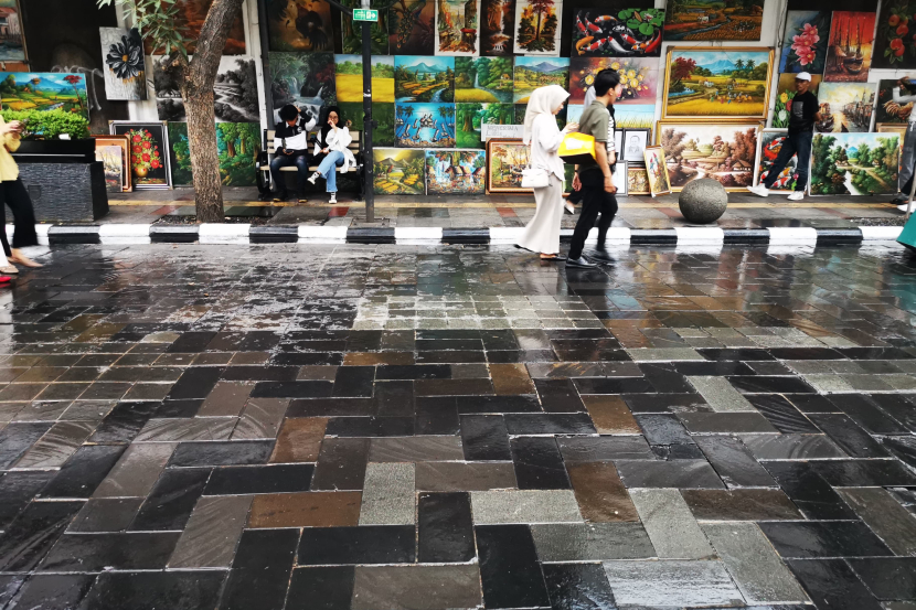 Suasana lengang jalan tanpa carut marut parkir kendaraan dengan latar pedagang lukisan pada pelaksanaan Braga Bebas Kendaraan (Braga Beken) di Jalan Braga Panjang, Sabtu (4/5/2024). (Foto Yogi Ardhi/Republika Network)